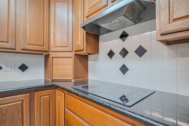 22010 Elsinore Dr, Katy, TX 77450 - kitchen with under cabinet range hood, black electric stovetop, backsplash, and brown cabinetry