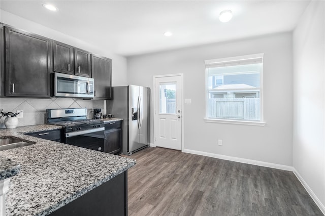 24511 Lorenzo Glaze Trl, Katy, TX 77493 - kitchen with stainless steel appliances, light stone counters, wood finished floors, baseboards, and recessed lighting