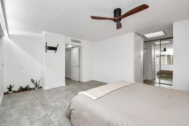 bedroom with light tile patterned floors, a ceiling fan, and baseboards