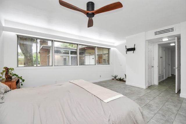 bedroom with ceiling fan, light tile patterned flooring, and baseboards