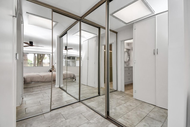 spacious closet with ceiling fan and light tile patterned flooring