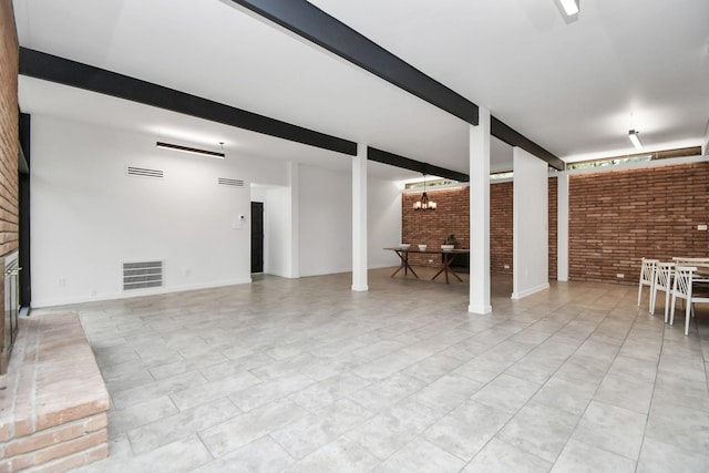 living area featuring brick wall, beamed ceiling, and a chandelier