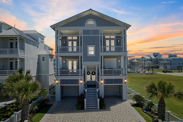3835 Seabreeze Ln, Galveston, TX 77554 - view of front facade with stairs, decorative driveway, an attached garage, and a balcony