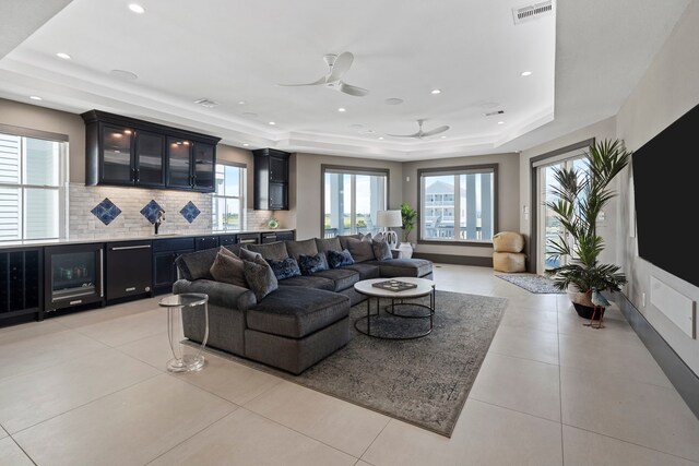 3835 Seabreeze Ln, Galveston, TX 77554 - living room with a raised ceiling, ceiling fan, bar, light tile patterned floors, and recessed lighting