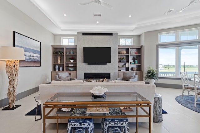 3835 Seabreeze Ln, Galveston, TX 77554 - living room with a large fireplace, ceiling fan, a tray ceiling, recessed lighting, and tile patterned flooring