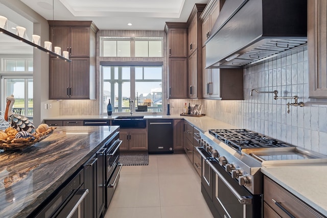 3835 Seabreeze Ln, Galveston, TX 77554 - kitchen featuring wall chimney range hood, range with two ovens, a sink, black dishwasher, and light tile patterned floors