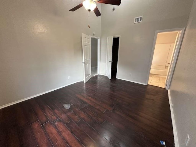 5919 Woodview Dr, Houston, TX 77396 - unfurnished bedroom with dark wood-type flooring, baseboards, a towering ceiling, a ceiling fan, and ensuite bath