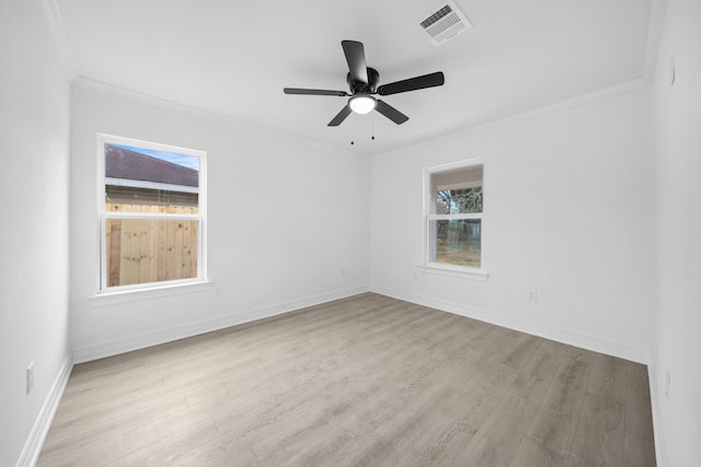 empty room with wood finished floors, baseboards, ceiling fan, and crown molding