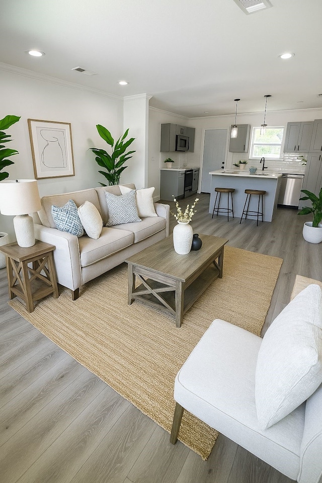 4930 Gren St, Houston, TX 77021 - living area featuring wood finished floors, recessed lighting, and ornamental molding
