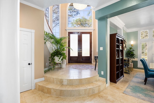 17511 Hawkin Ln, Tomball, TX 77377 - foyer entrance with ornamental molding, french doors, baseboards, a chandelier, and a high ceiling