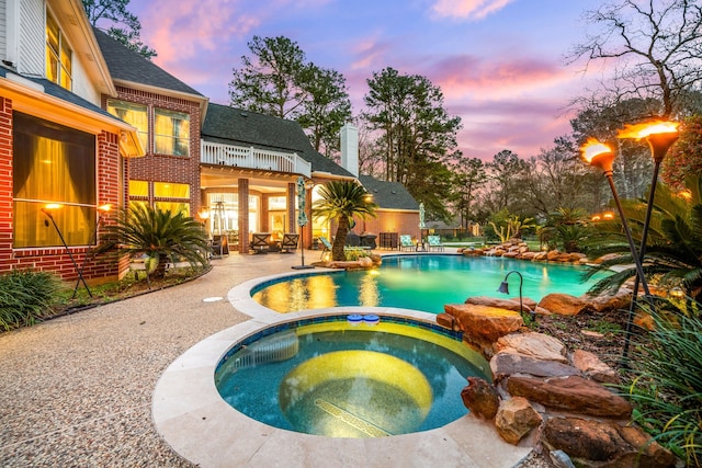17511 Hawkin Ln, Tomball, TX 77377 - pool at dusk featuring a patio and a pool with connected hot tub