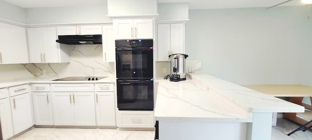 7515 Hopewell Ln, Houston, TX 77071 - kitchen with under cabinet range hood, black appliances, a peninsula, and white cabinets