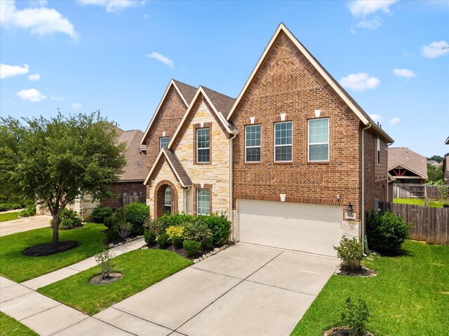 18118 Berry Garden Ln, Spring, TX 77379 - view of front of home with an attached garage, brick siding, driveway, and stone siding