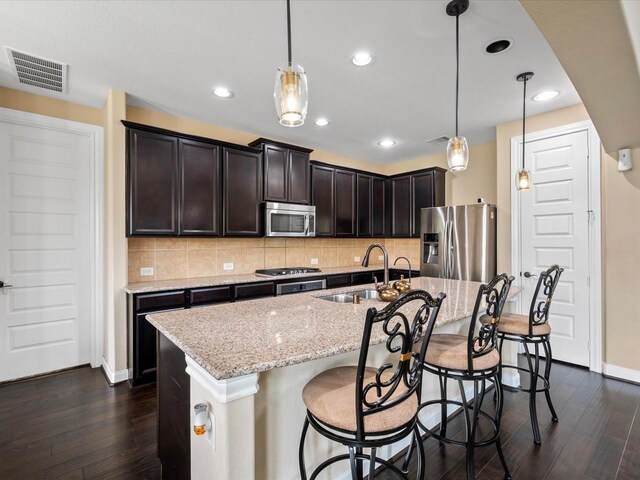 18118 Berry Garden Ln, Spring, TX 77379 - kitchen featuring stainless steel appliances, a sink, dark wood finished floors, light stone countertops, and recessed lighting