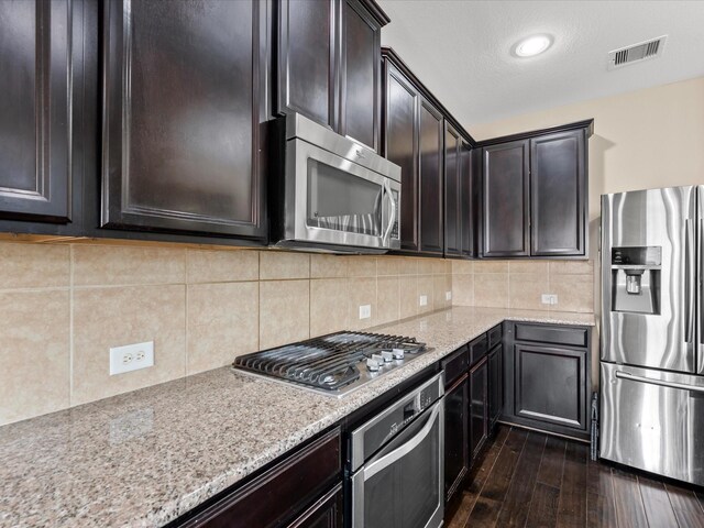 18118 Berry Garden Ln, Spring, TX 77379 - kitchen featuring stainless steel appliances, light stone counters, dark wood-style flooring, and decorative backsplash