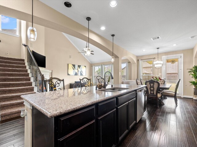 18118 Berry Garden Ln, Spring, TX 77379 - kitchen with a sink, dark cabinets, stainless steel dishwasher, arched walkways, and an island with sink