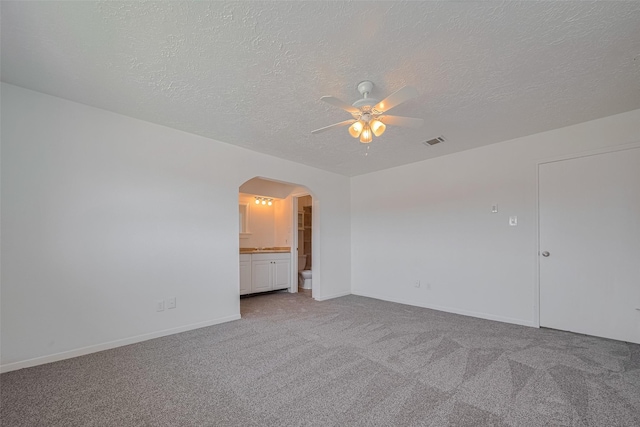 10306 Jillana Kaye Dr, Houston, TX 77086 - carpeted spare room with arched walkways, a ceiling fan, a textured ceiling, and baseboards