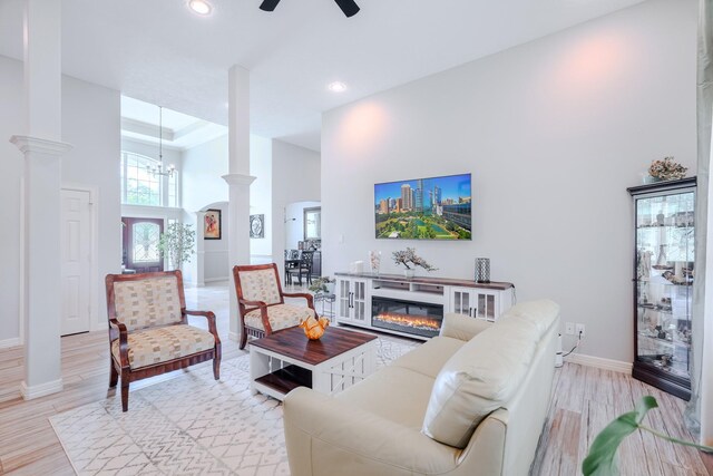 3907 Movado Ct, Spring, TX 77386 - living area with ornate columns, a towering ceiling, a ceiling fan, a glass covered fireplace, and baseboards