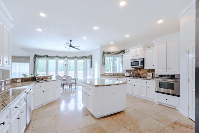 3907 Movado Ct, Spring, TX 77386 - kitchen with appliances with stainless steel finishes, a sink, ceiling fan, backsplash, and white cabinetry