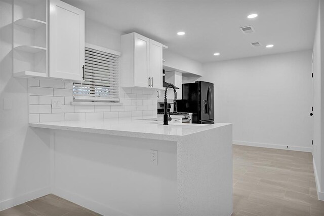 10938 Fleming Dr, Houston, TX 77013 - kitchen featuring open shelves, black fridge with ice dispenser, white cabinets, baseboards, and recessed lighting