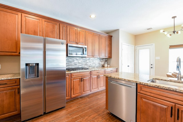 20815 Winlock Trace Dr, Katy, TX 77450 - kitchen featuring appliances with stainless steel finishes, a sink, brown cabinets, and recessed lighting