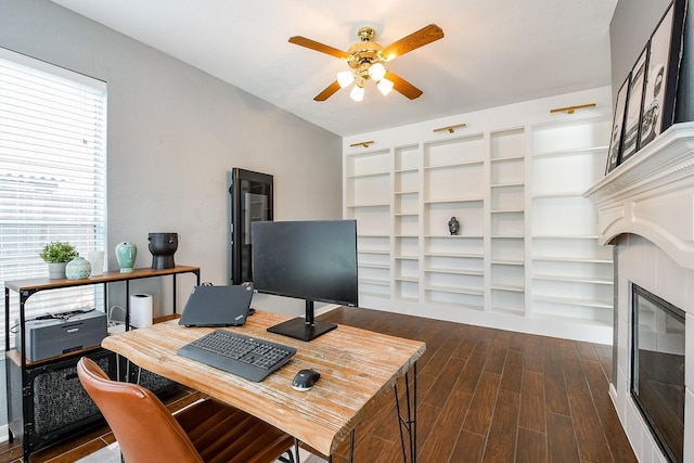 20815 Winlock Trace Dr, Katy, TX 77450 - home office featuring a glass covered fireplace, ceiling fan, and dark wood finished floors