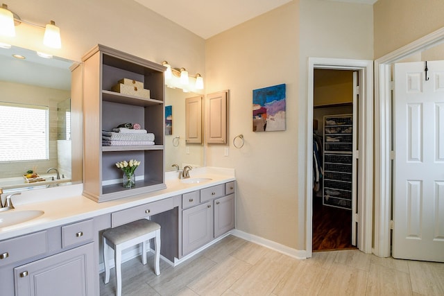 20815 Winlock Trace Dr, Katy, TX 77450 - bathroom featuring double vanity, a bath, a spacious closet, baseboards, and a shower
