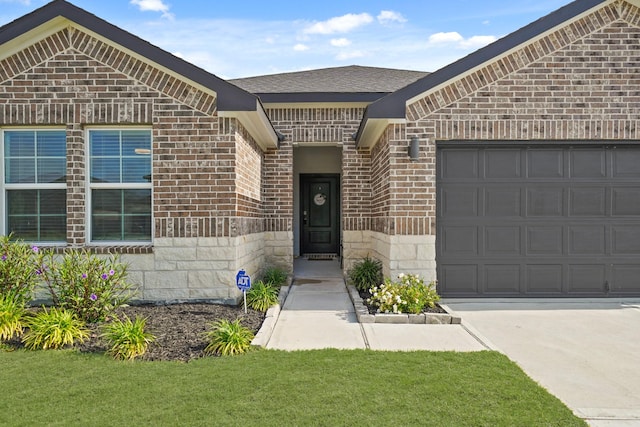 1103 Curly Angora Ct, Rosharon, TX 77583 - entrance to property with brick siding, a garage, driveway, stone siding, and a yard