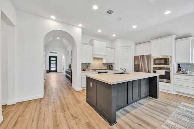 19015 Giara Pony Trl, Tomball, TX 77377 - kitchen with appliances with stainless steel finishes, light wood-style floors, light countertops, backsplash, and recessed lighting