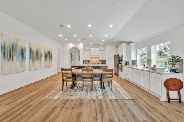 19015 Giara Pony Trl, Tomball, TX 77377 - dining area featuring light wood-style floors, arched walkways, and recessed lighting