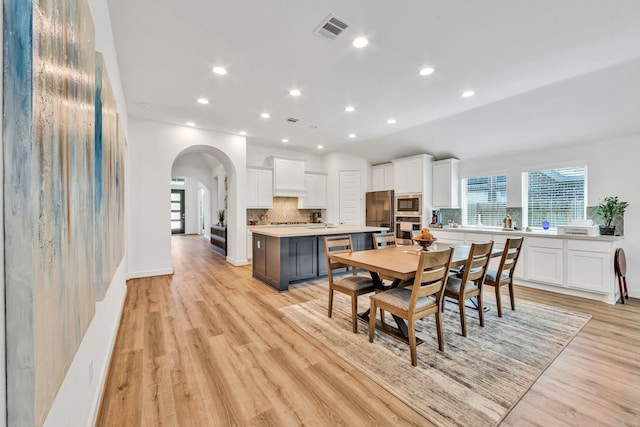 19015 Giara Pony Trl, Tomball, TX 77377 - dining space featuring arched walkways, light wood-style flooring, and recessed lighting