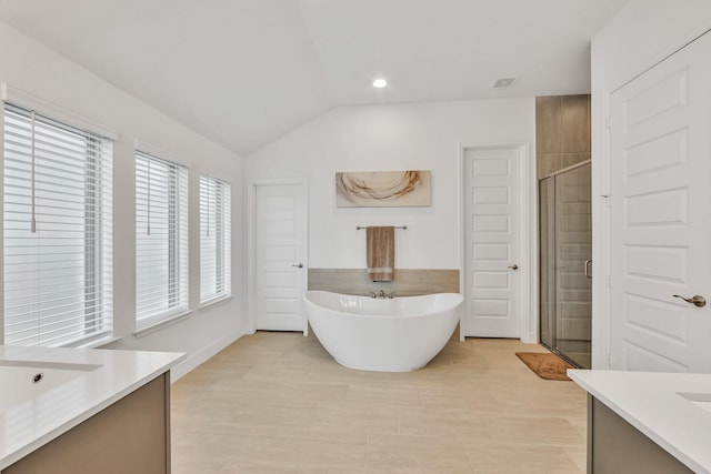 19015 Giara Pony Trl, Tomball, TX 77377 - bathroom featuring vanity, a freestanding tub, a stall shower, vaulted ceiling, and tile patterned flooring