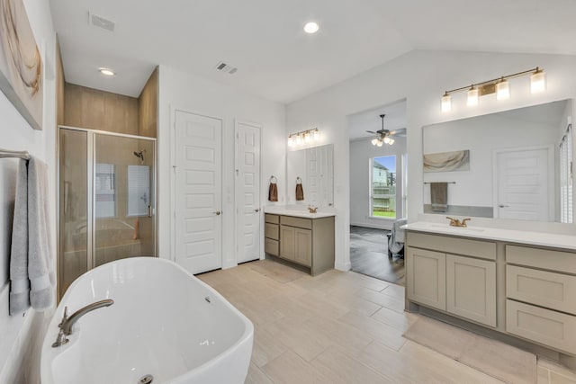 19015 Giara Pony Trl, Tomball, TX 77377 - bathroom featuring a soaking tub, a shower stall, two vanities, a ceiling fan, and vaulted ceiling