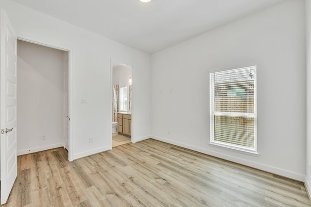 19015 Giara Pony Trl, Tomball, TX 77377 - unfurnished bedroom with light wood finished floors and ensuite bathroom