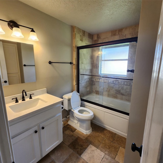 3625 Whatley Dr, Deer Park, TX 77536 - full bath with a textured ceiling, toilet, combined bath / shower with glass door, vanity, and stone finish floors