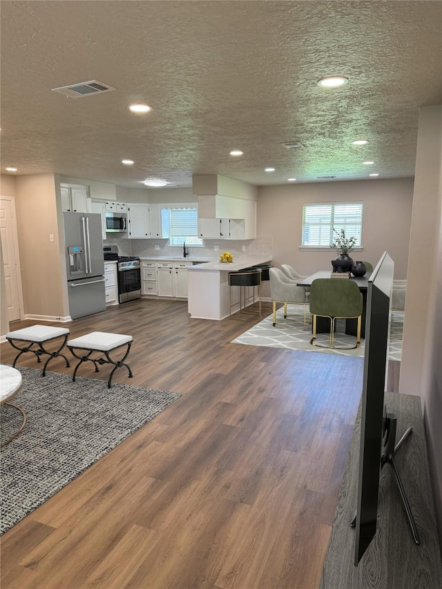 3625 Whatley Dr, Deer Park, TX 77536 - living area featuring recessed lighting, dark wood-type flooring, and a textured ceiling