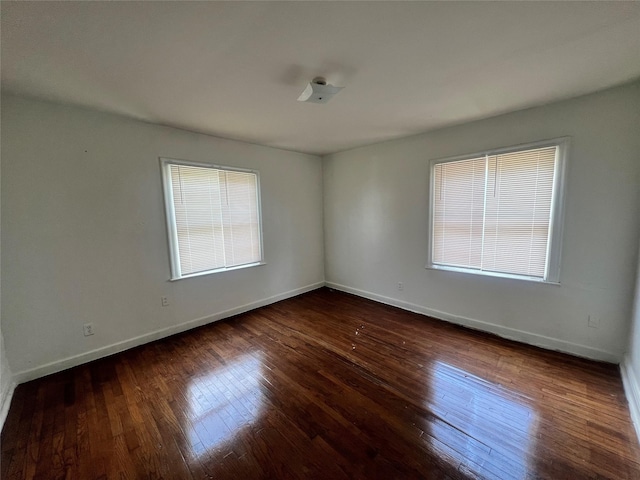 unfurnished room with plenty of natural light, hardwood / wood-style floors, and baseboards