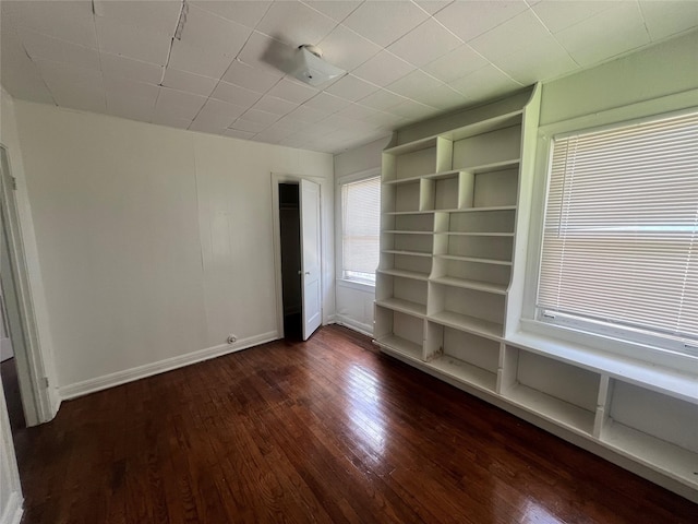 unfurnished room featuring dark wood-style floors and baseboards