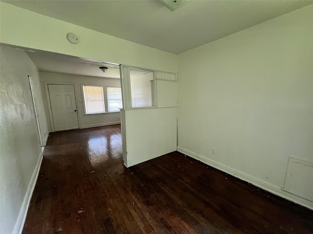 empty room with hardwood / wood-style flooring, baseboards, and a smoke detector