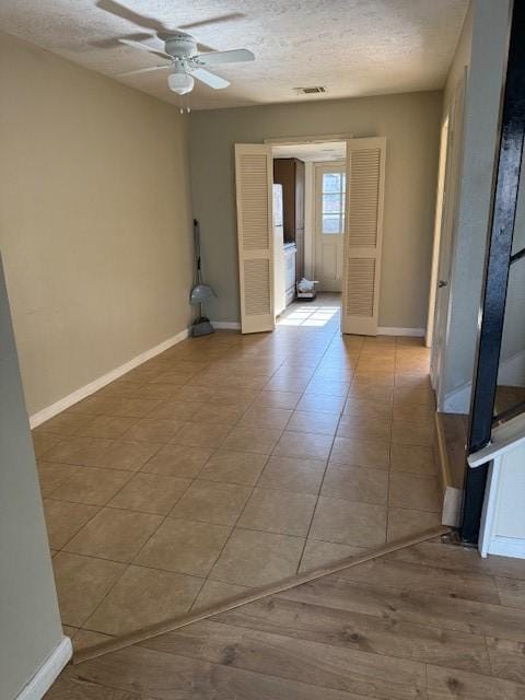 7358 Crownwest St Unit 7358, Houston, TX 77072 - unfurnished room featuring ceiling fan, baseboards, a textured ceiling, and light tile patterned flooring