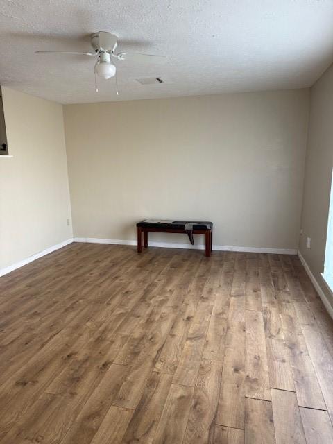 7358 Crownwest St Unit 7358, Houston, TX 77072 - empty room with wood finished floors, a ceiling fan, baseboards, and a textured ceiling