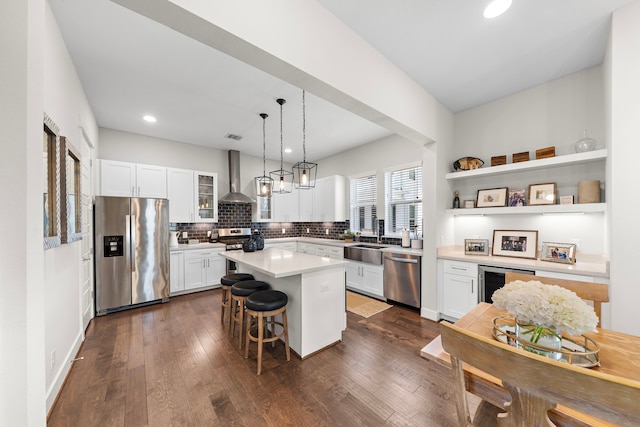 1226 W 17th St Unit D, Houston, TX 77008 - kitchen featuring stainless steel appliances, a kitchen bar, white cabinetry, wall chimney range hood, and a sink