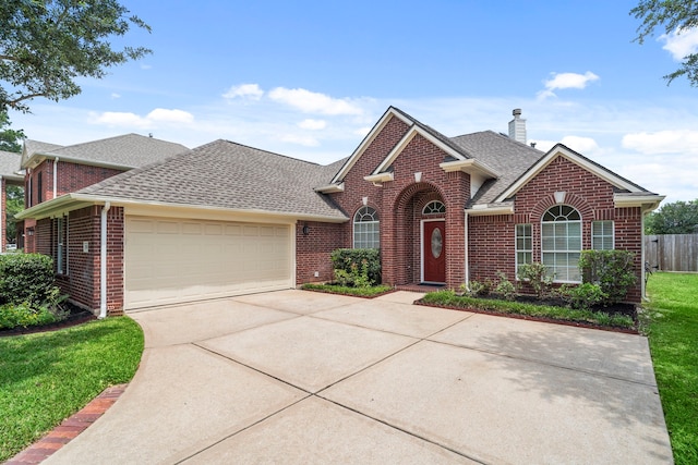 20506 Nellie Gail Trail Ln, Katy, TX 77450 - traditional-style home featuring brick siding, roof with shingles, a garage, concrete driveway, and a chimney