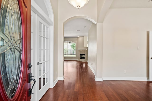 20506 Nellie Gail Trail Ln, Katy, TX 77450 - foyer entrance featuring arched walkways, dark wood-style floors, baseboards, and a tile fireplace