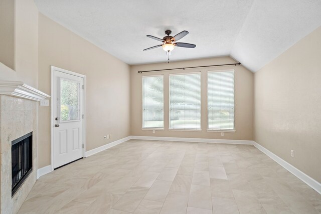 20506 Nellie Gail Trail Ln, Katy, TX 77450 - unfurnished living room with a ceiling fan, a fireplace, vaulted ceiling, baseboards, and a textured ceiling