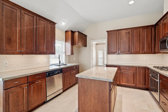 20506 Nellie Gail Trail Ln, Katy, TX 77450 - kitchen with appliances with stainless steel finishes, a sink, vaulted ceiling, light stone countertops, and backsplash