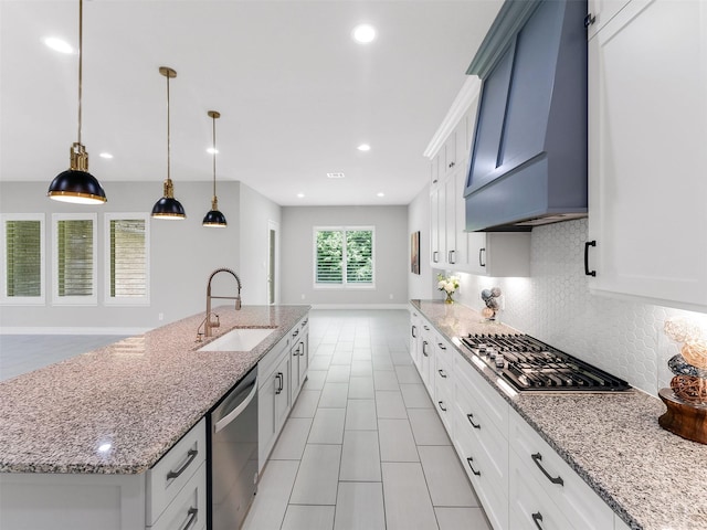 15806 Gibson Grass Ct, Spring, TX 77379 - kitchen with a sink, appliances with stainless steel finishes, premium range hood, a kitchen island with sink, and tasteful backsplash