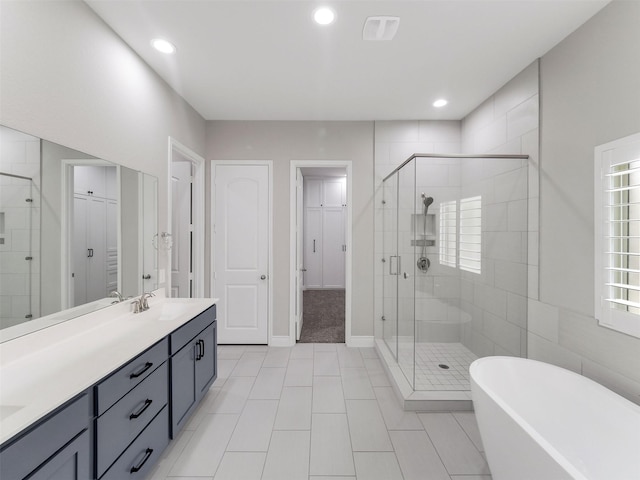 15806 Gibson Grass Ct, Spring, TX 77379 - full bathroom featuring a stall shower, double vanity, a freestanding bath, recessed lighting, and tile patterned flooring
