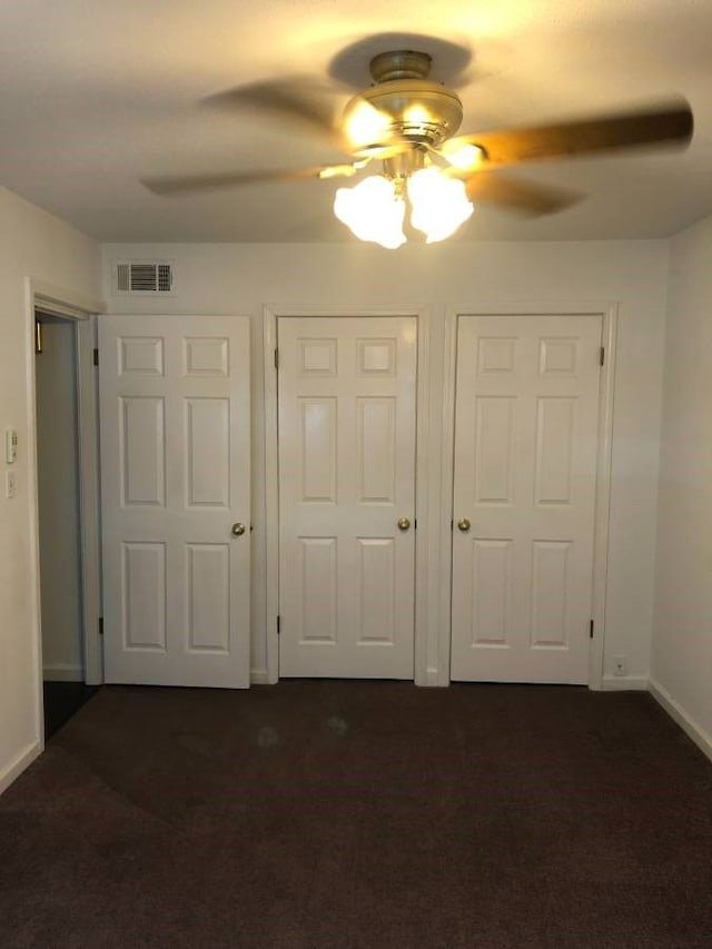 2101 Fountain View Dr Unit 77, Houston, TX 77057 - unfurnished bedroom with dark carpet, baseboards, and ceiling fan