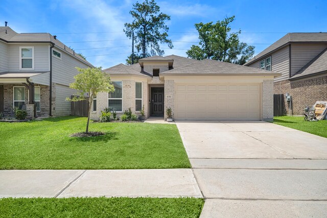 11311 Cascading Stream Way, Houston, TX 77044 - view of front of home with an attached garage, brick siding, a front lawn, and concrete driveway
